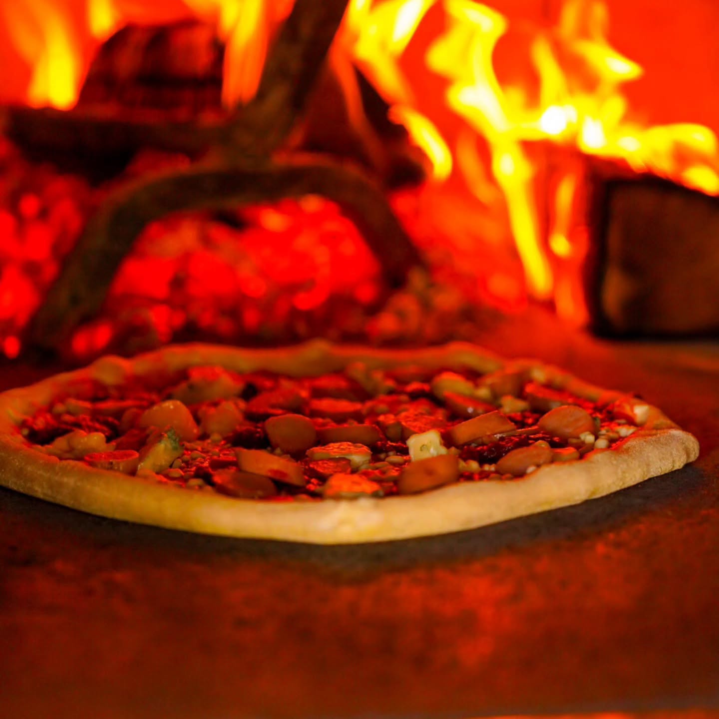 Pizza cooking on the stone in the wood fired oven