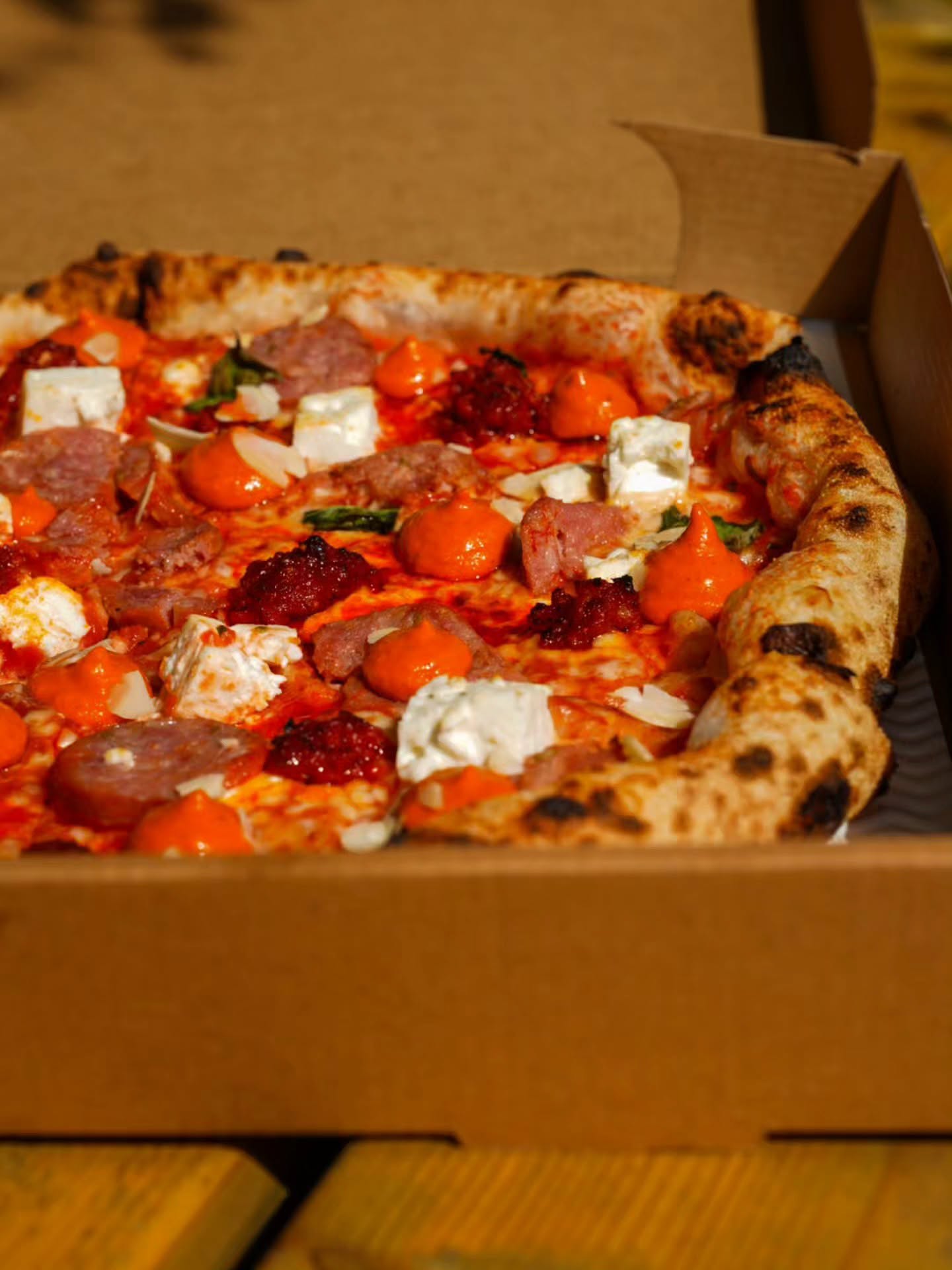 Pizza with salami, soft cheese and chilli in a box