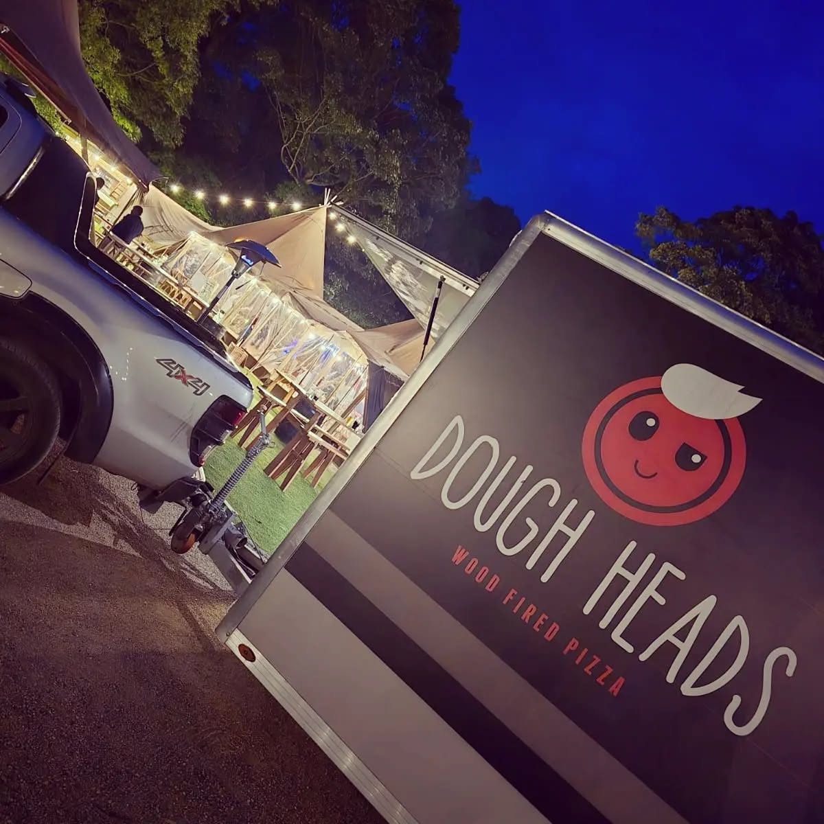 The Dough Heads trailer set up beside a lit marquee at an evening event